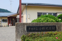 厚木市立小野児童館と書かれた門があり、奥に白い壁の小野児童館が写っている正面写真