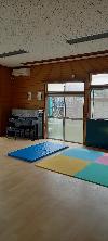 最近、床をリフォームしてきれいになりました。広々とした部屋にピアノや卓球台が置かれている吾妻町児童館の遊戯室の写真