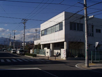 白を基調とした2階建の道路補修事務所を向かい側から撮影している写真