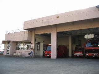 2階建ての事務所に隣接する車庫に消防車両が数台駐車されている北消防署小鮎分署の写真