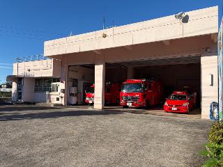 2階建ての事務所に隣接する車庫に消防車両が数台駐車されている北消防署小鮎分署の写真