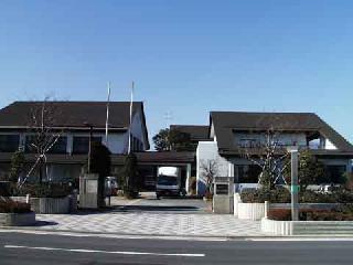 建物と建物の間の通路にトラックが駐車されている相川公民館・地区市民センターを道路側から撮影した写真