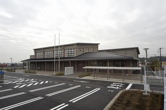 2階建ての荻野公民館・地区市民センターの手前に掲揚台、駐輪所、駐車場が写っている写真