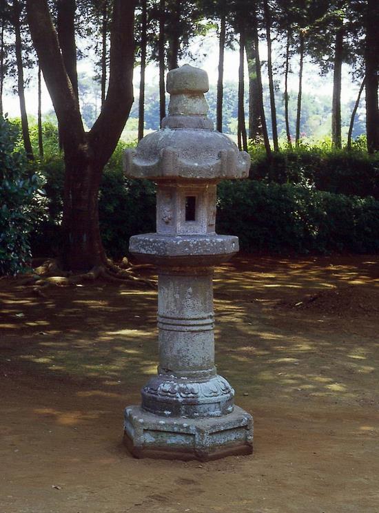 木々に囲まれているなかに設置されてある石灯籠の写真