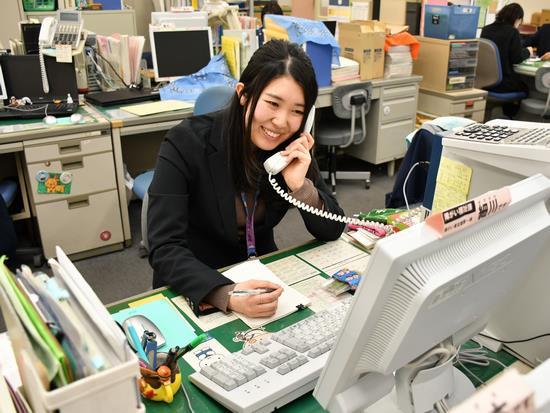 メモを取りながら電話応対をしている女性職員の写真
