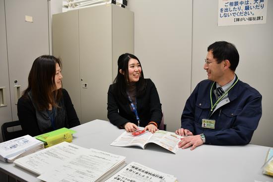 2人の同僚と話をしている女性職員の写真