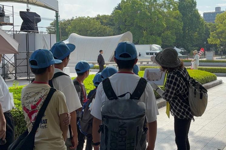 ボランティアガイドと平和記念公園を見学する参加者