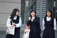 制服を着た3人の女子学生が並んで歩いている写真