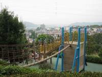 アスレチックの遊具の一番高い所から、丘の上の高所までロープで繋がっている写真