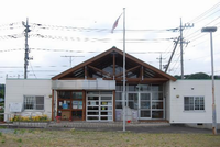 白を基調としたロッジ風建物の下川入児童館の前に旗が立てられている写真