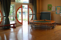 広々としたフローリングにトランポリンや平均台が置いてある上依知児童館の遊戯室の写真