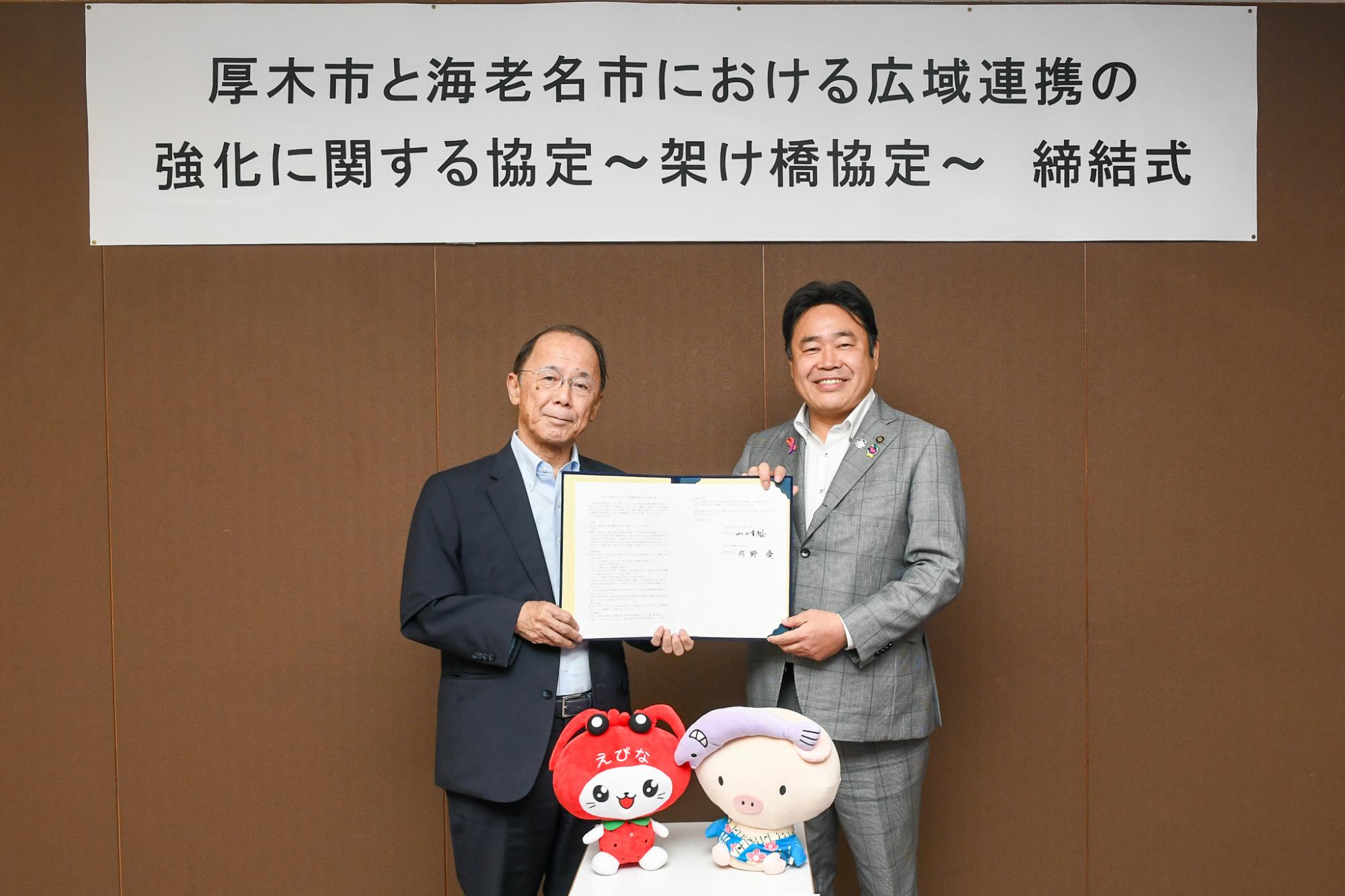 協定書を手にした両市長