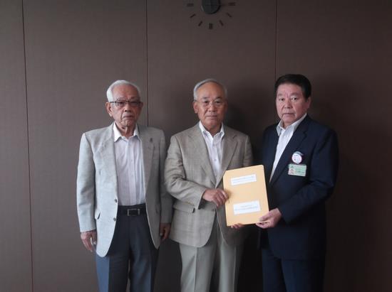 三田哲夫委員長と小林市長が一緒に提言書を持ち、池本委員長職務代理も一緒に並んで記念撮影している写真