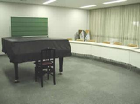 第303号会議室のピアノと椅子とカーテンが写っている写真