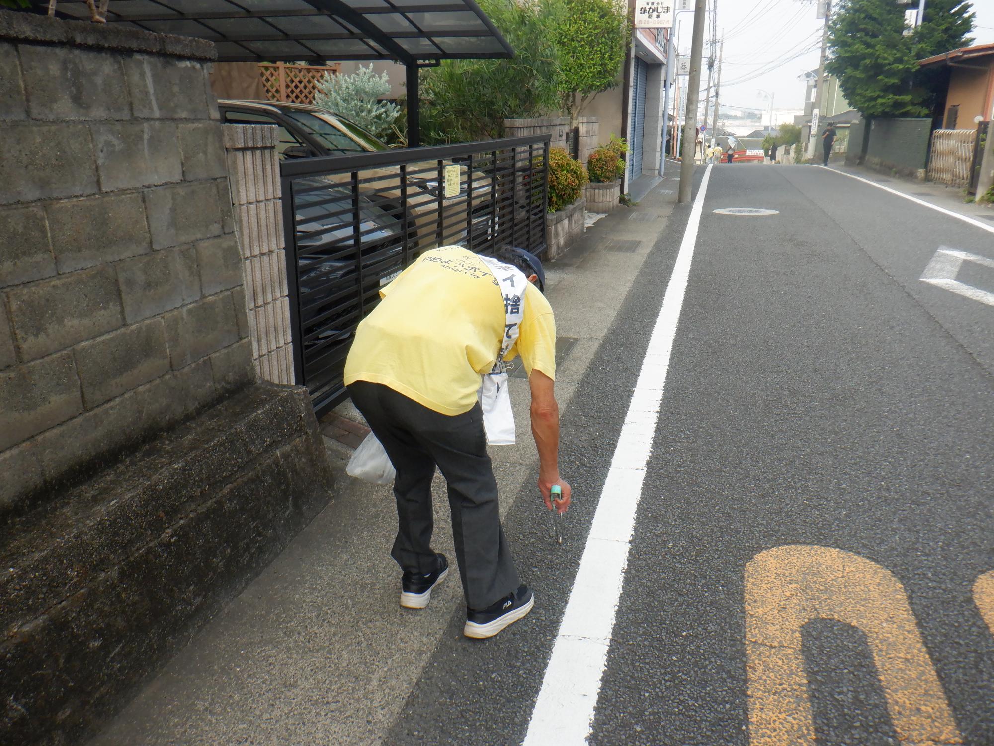 7月8日に実施した路上喫煙・ポイ捨て防止キャンペーンでパトロールをしながらポイ捨てされたごみを拾っている写真