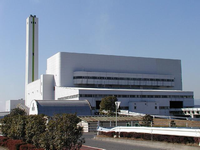 白い長方形の建物の左横後方に白い煙突が立っている現在の環境センター全景の写真