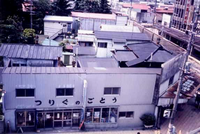 老朽化している店舗などの建物や低層の木造家屋、老朽化したビルが建ち並んでいる商店街を高台から撮影した写真