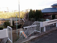 急な坂道の途中にあり、すべり台が設置されている島崎公園を上から撮影した写真