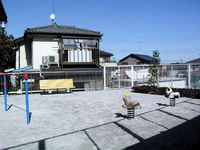 白色のフェンスで囲まれた園内に、ベンチや鉄棒、2つの動物の形をしたスプリング遊具が設置されている吾妻公園の写真