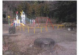 樹木に囲まれた場所にあり、ブランコやロケットのような形をした遊具などが設置されている、とびおみね公園の写真