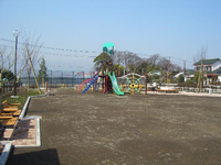 黒色の柵で囲まれた園内左側に手置き付きの2つのベンチがあり、奥には複合遊具が設置設置されている公園の写真
