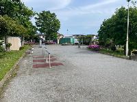 住宅街の一角にあり、周囲に植木や樹木が点在しており、左側には高さの違う鉄棒やベンチ右側には水飲み場がが設置されている、とびおにし公園