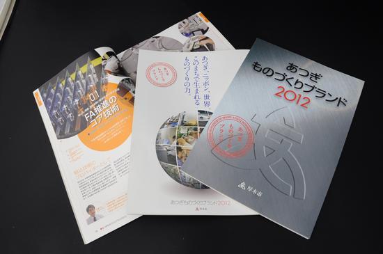 あつぎものづくりブランド2012の冊子が机の上に広げられている写真