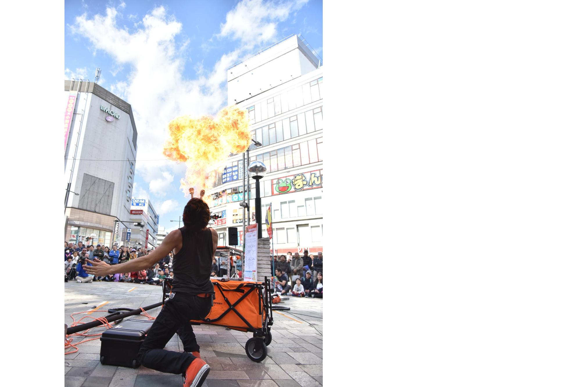 駅前北口広場で繰り広げられる迫力の火吹きパフォーマンスの写真