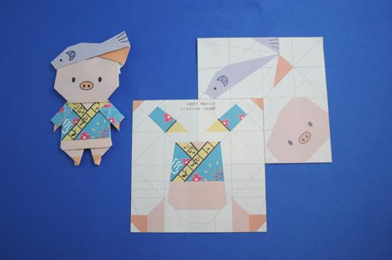 折り紙で折られたあゆコロちゃんと2枚のあゆコロちゃん折り紙の写真