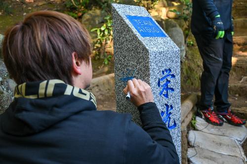 白山ハイキングコース入口「栄光への坂道」にサインを書いている三嶋選手