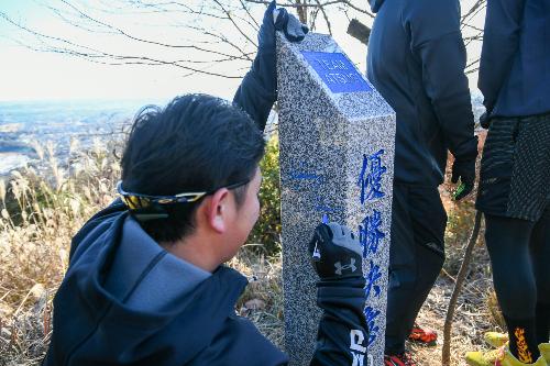 白山ハイキングコース山頂「優勝決意の地」にサインを書いている山崎選手