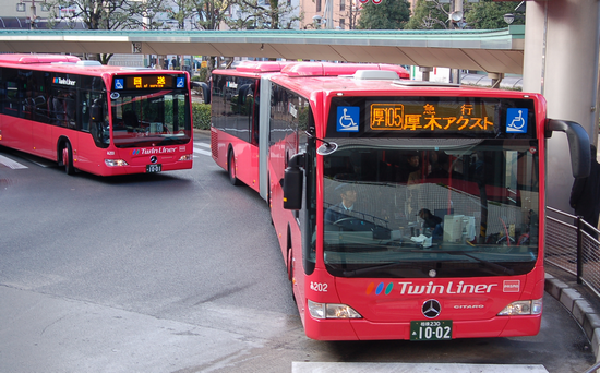 赤い車体の路面バスが3台連なっている写真