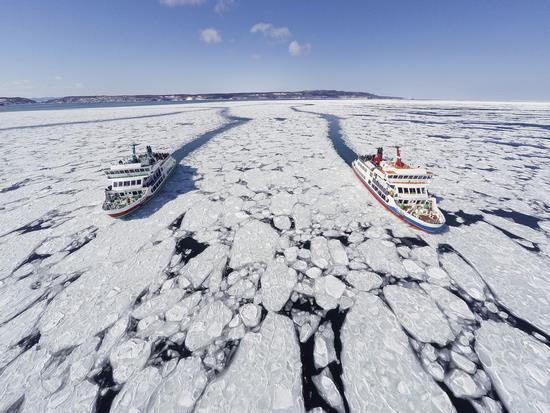 流氷の氷をかき分けながら2隻のクルーズ船が走っている写真