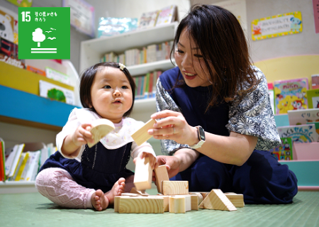 市内産間伐材を使った積み木で遊ぶ親子の写真