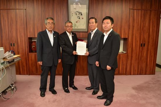 川口議長と石井委員長が両手で答申書を持ちその両サイドにスーツ姿の男性2名がたっている写真