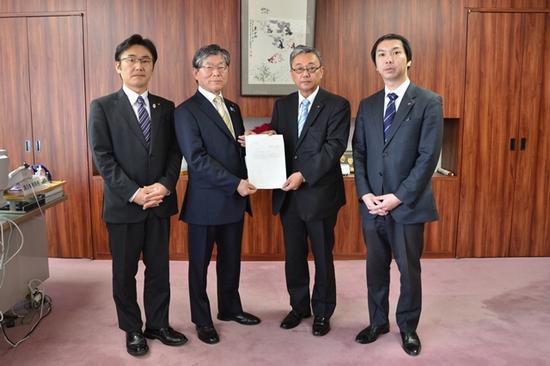 石井議長と川口委員長が両手で答申書を持ち両脇に男性が2人立っている写真