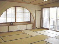半円形の窓のある広々とした和室の写真