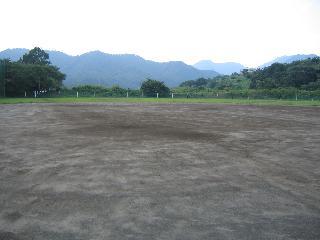 広々とした野球のグラウンド(飯山スポーツ広場)の奥に山が見えている写真