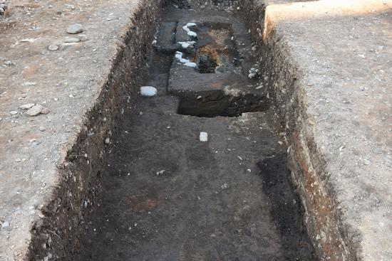 縦に長く、地面から1メートルくらい掘られた発掘調査された遺跡の写真