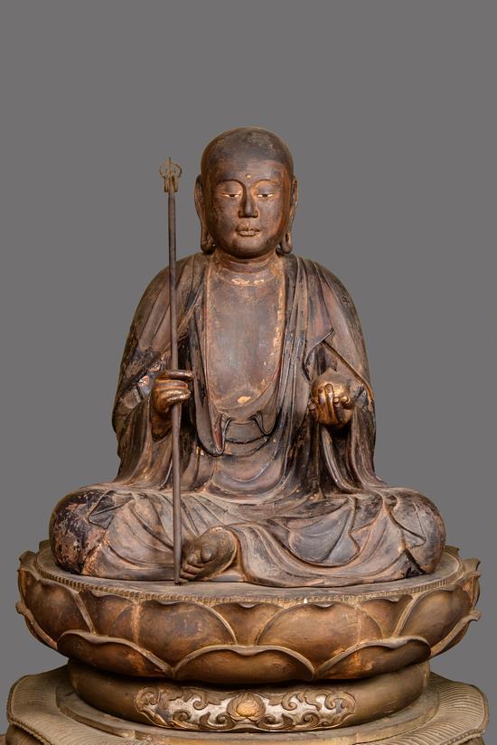 袈裟を身にまとい左手に如意宝珠、右手に錫杖を持つ地蔵菩薩坐像の全身の写真