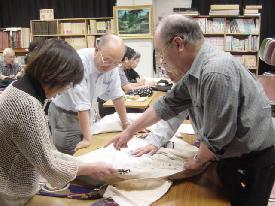 3人の人々が白い服を調べているの写真