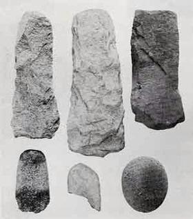 下半分に磨製石斧が3点並んでおり左から縦長の楕円形、中央は左下に欠けがあり、右は丸型、上半分の3点は大形の短冊形打製石斧が並んでいる写真