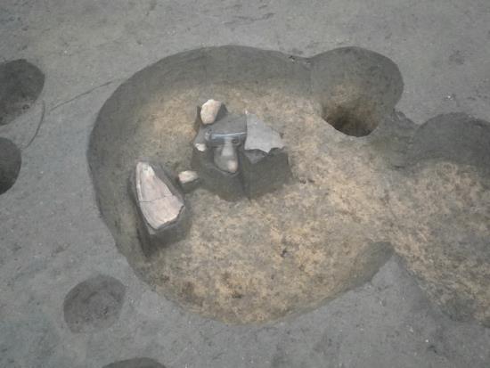 2つの円形が重なったような形をして、上に大きな円形の窪みがある土坑墓の写真