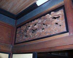 襖の上に立派な彫刻が施されている欄間のある古民家岸邸1階の写真