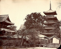 寺の境内の左側と奥にお堂、右側に五重の塔がそびえ立つ白黒写真