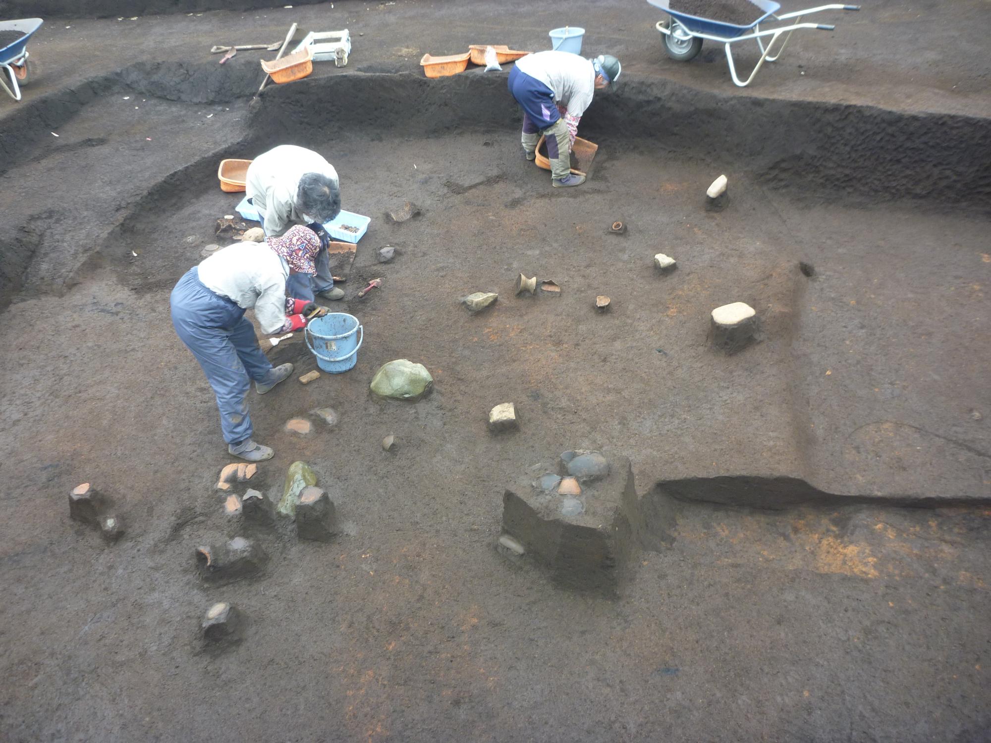 竪穴住居から遺物を発掘している様子