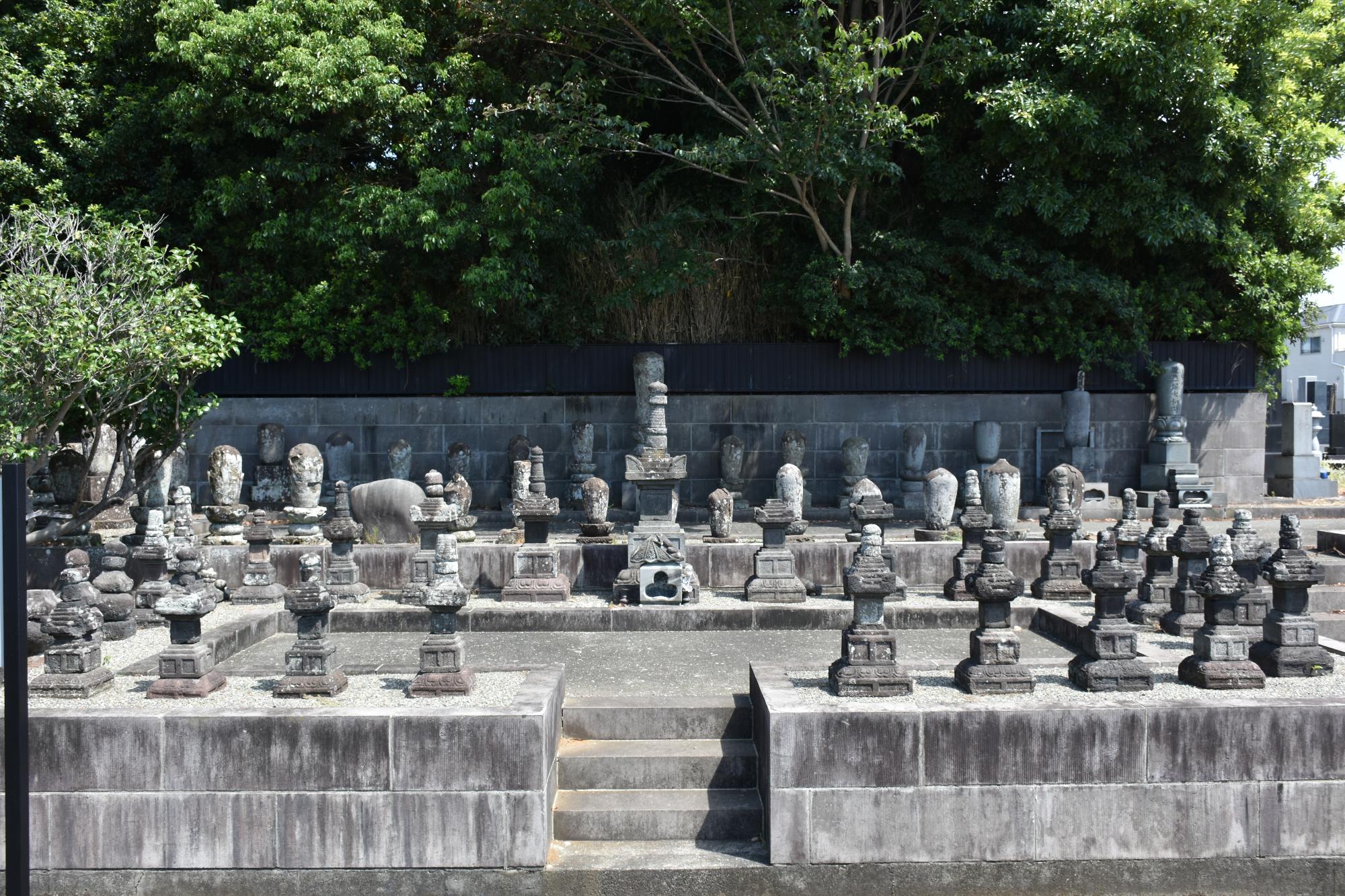 本間氏累代の墓と伝えられる石造物 宝篋印塔と五輪塔が並んでいる写真