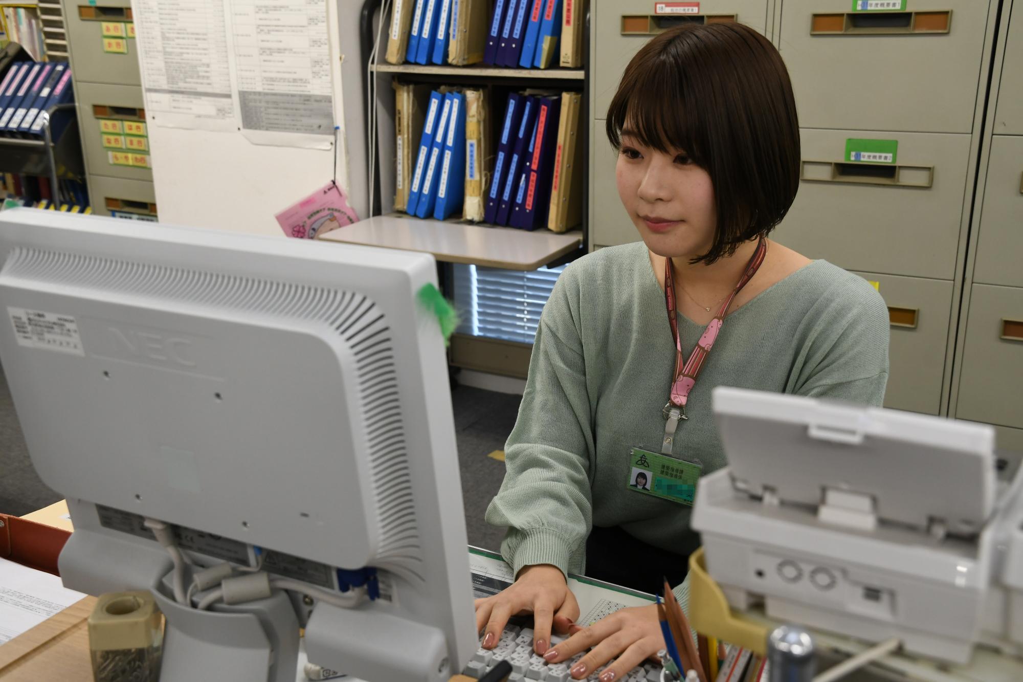 パソコンに向かって報告書の作成をしている建築職の女性職員の写真