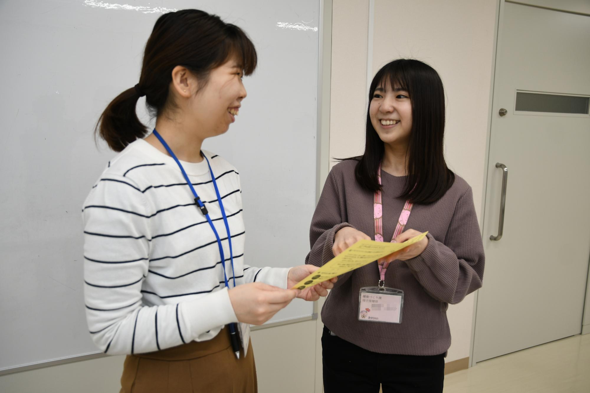 同僚と仕事の相談をしている女性保健師の写真