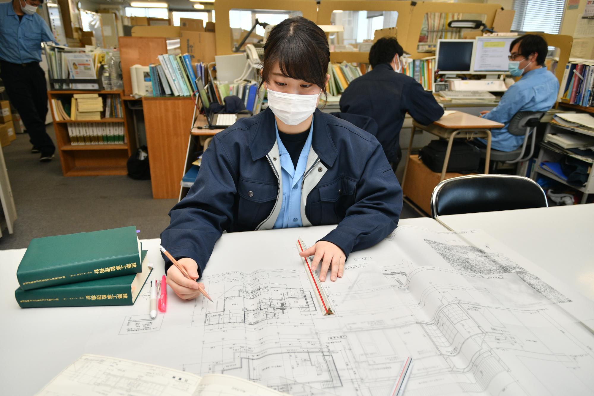 図面の確認をしている建築職の女性職員の写真